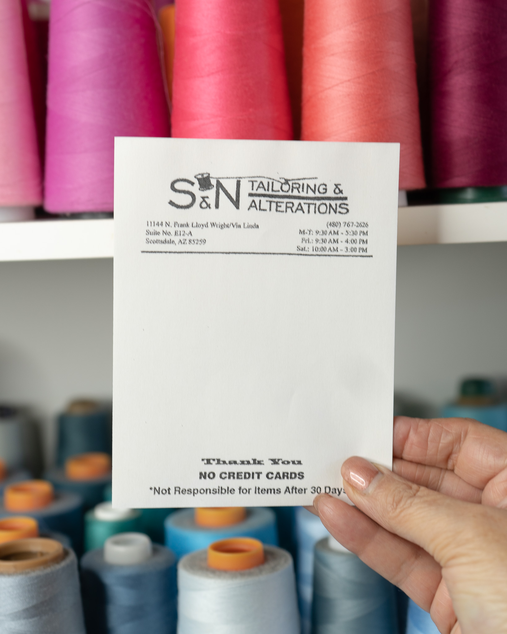 S & N Tailoring business card with colorful thread spools